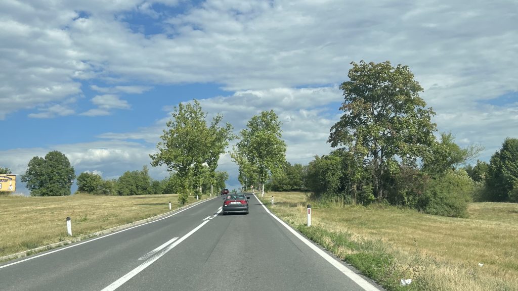 Una carretera de Croacia, con verde a los lados y el cielo de fondo