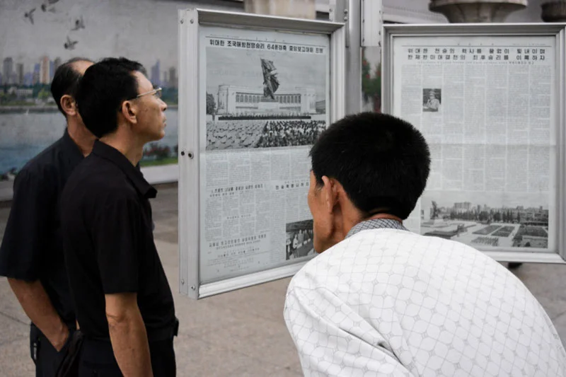 Los norcoreanos leyendo el periódico en la estación de metro de Pyongyang