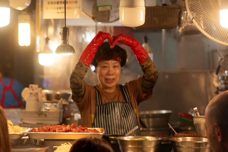 Una mujer atendiendo un puesto de street food en el Gwangjang Market, en Seúl.